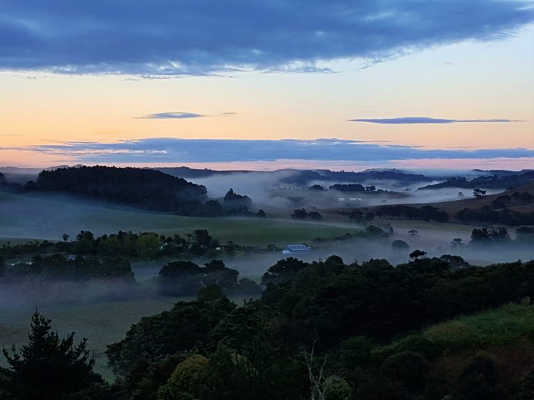 View of the valley with fog lingering over the Kaipara river meandering through the valley