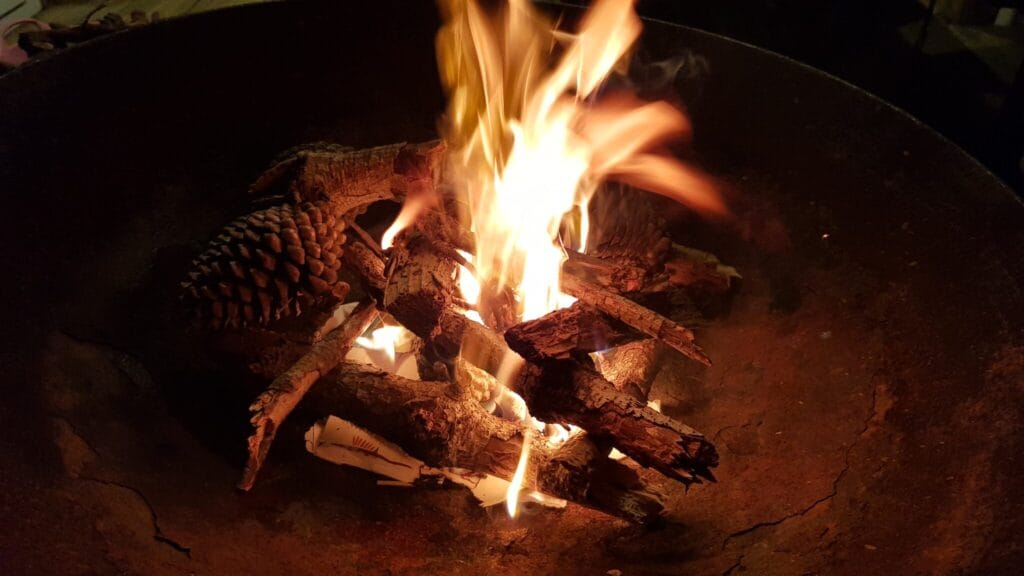 A fire at darkness in a metal bown, closeup