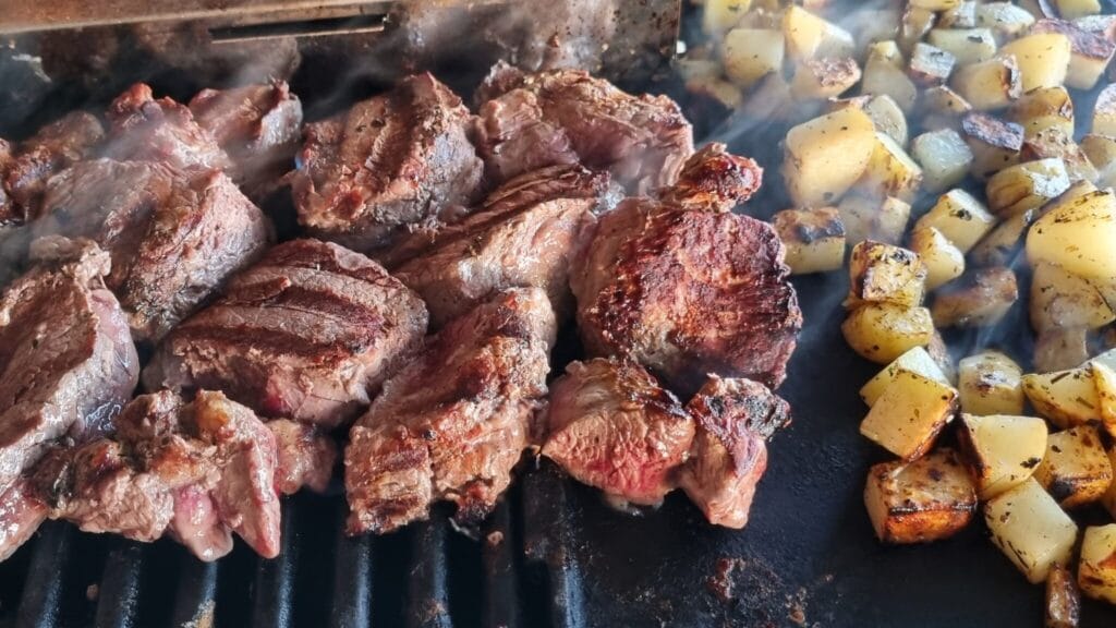 Cubed potatoes and meat on BBQ