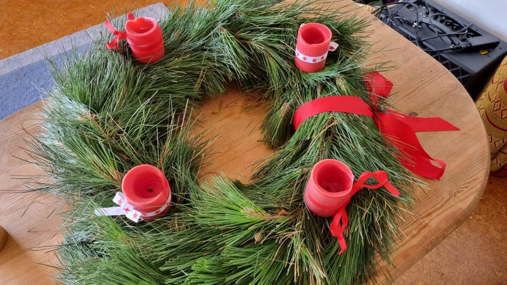 Wreath made from pine branches with red cancdles stuck on it