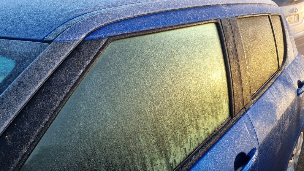 A car with frozen windscreen and windows