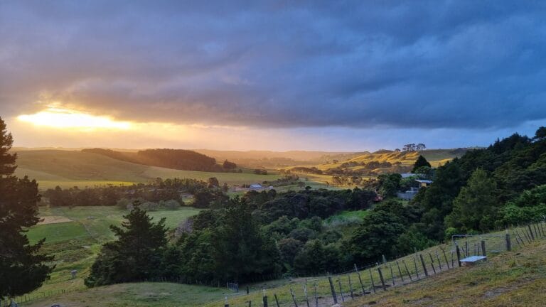 Stormy dark sky with sun lit valley.